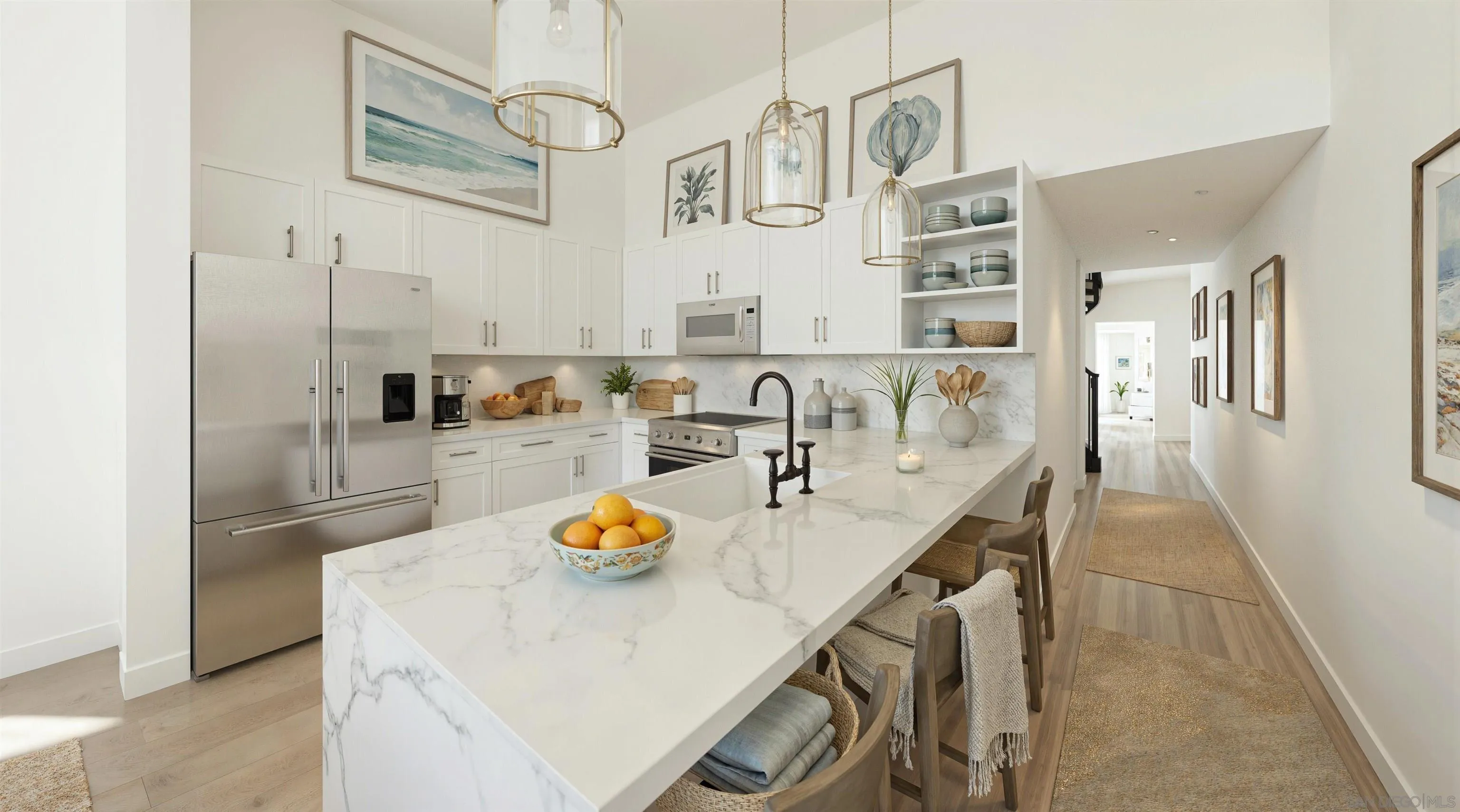 Kitchen with a large marble-look island, white cabinetry, stainless steel appliances, and brass pendant lights.