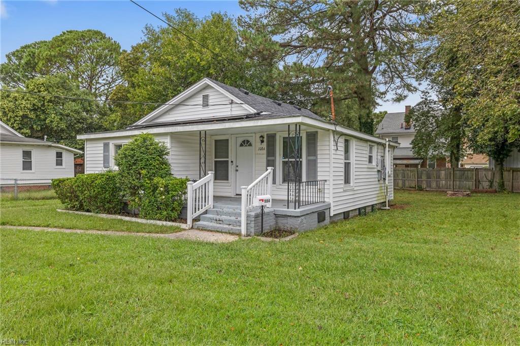 White single-story house with a small covered porch and broad green lawn.