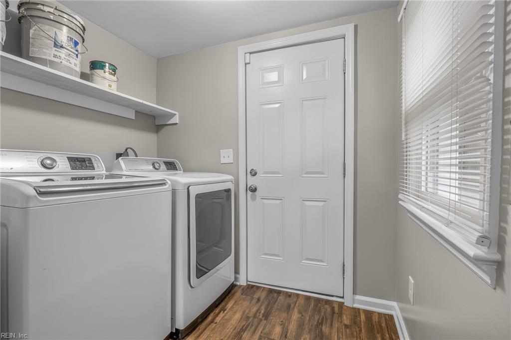 Laundry room with washer, dryer, wall shelf, and a white door beside a window with blinds.