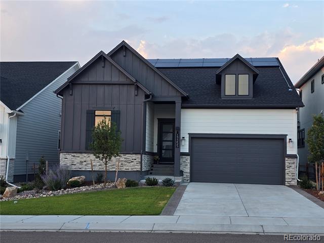 Modern home with charcoal siding, stone accents, and a two-car garage.