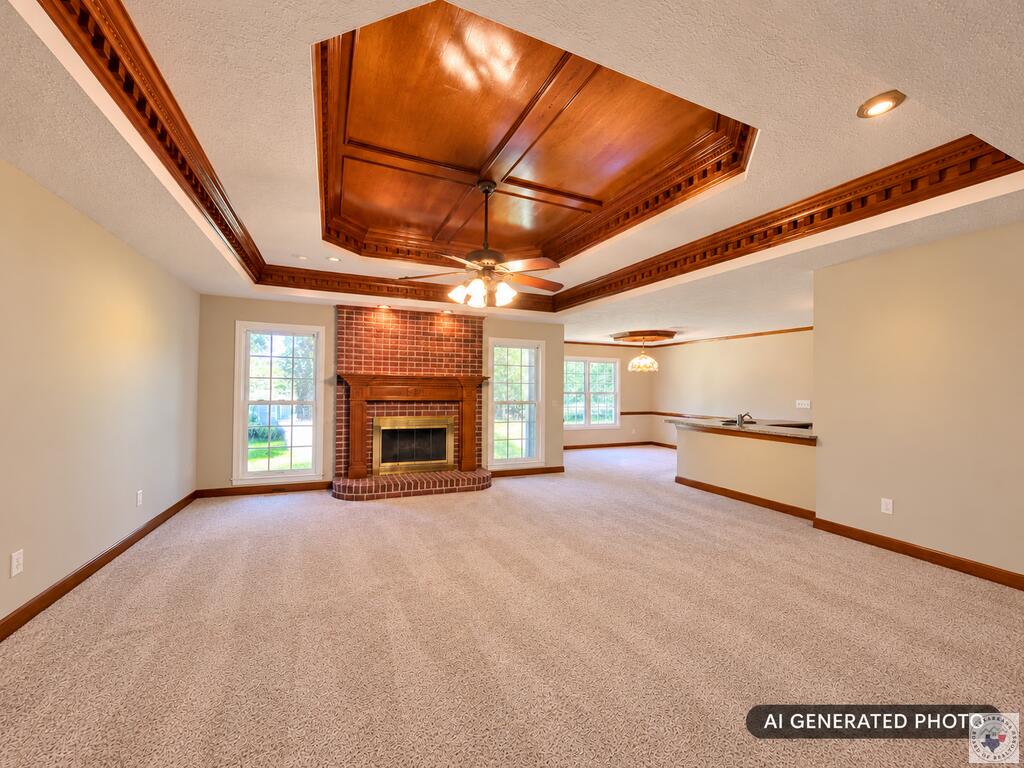Vacant living room with a brick fireplace, ornate wood ceiling, and open kitchen area.