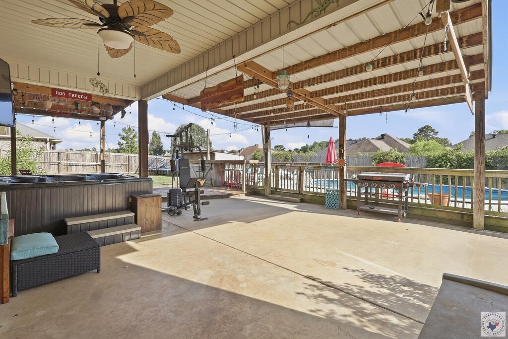 Covered patio with hot tub, outdoor grill, ceiling fan, and backyard swimming pool.