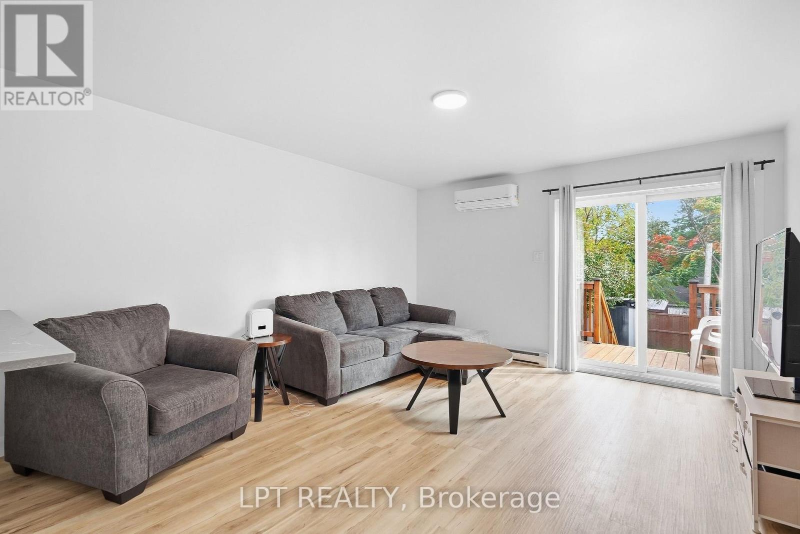 Furnished living room with gray sofas and sliding doors opening onto a deck.
