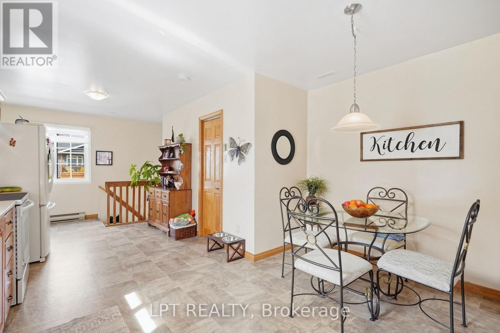 Kitchen and dining area with a glass-top table, metal chairs, and stainless-steel refrigerator.