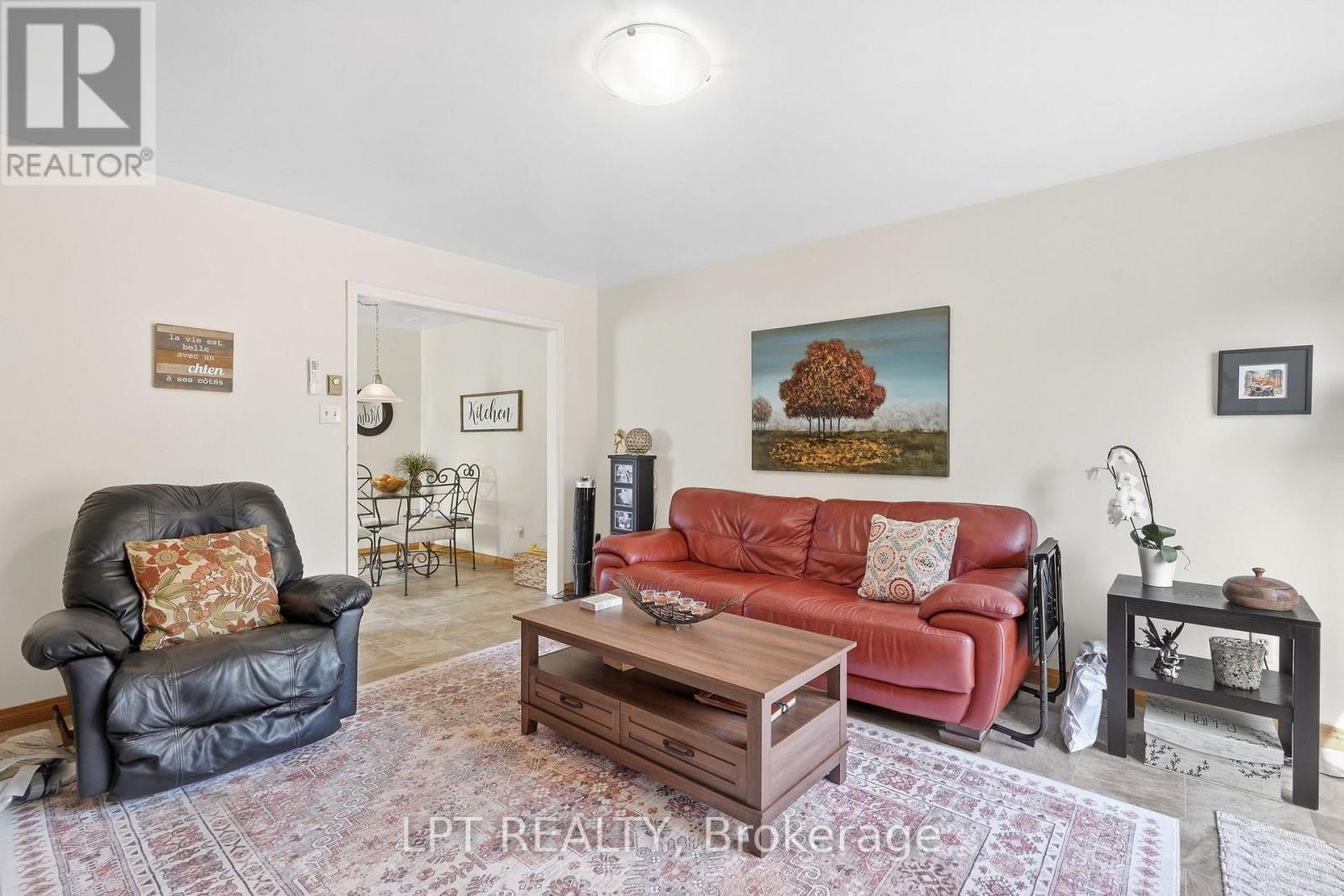 Living room with a red leather sofa, black recliner, and patterned rug.