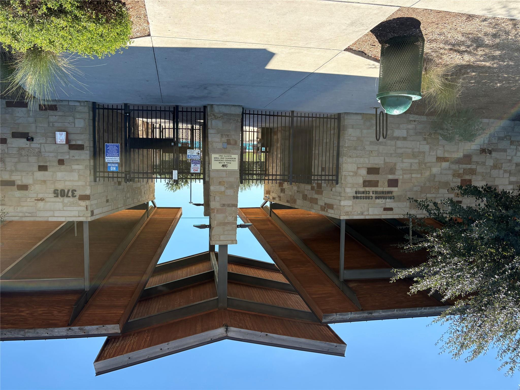 Colorado Crossing amenities center pool entrance with a stone facade and broad timber canopy.