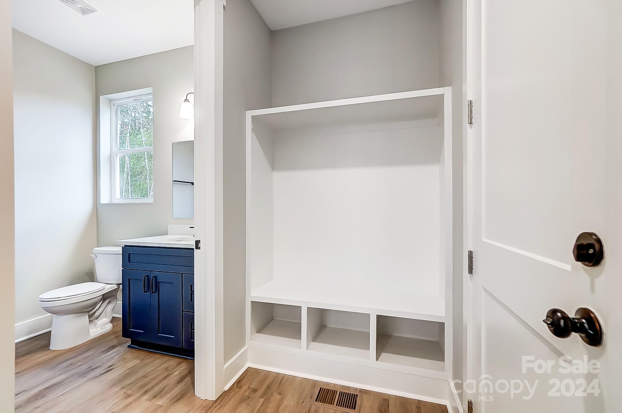 Bathroom with a navy-blue vanity and large white built-in shelving unit.