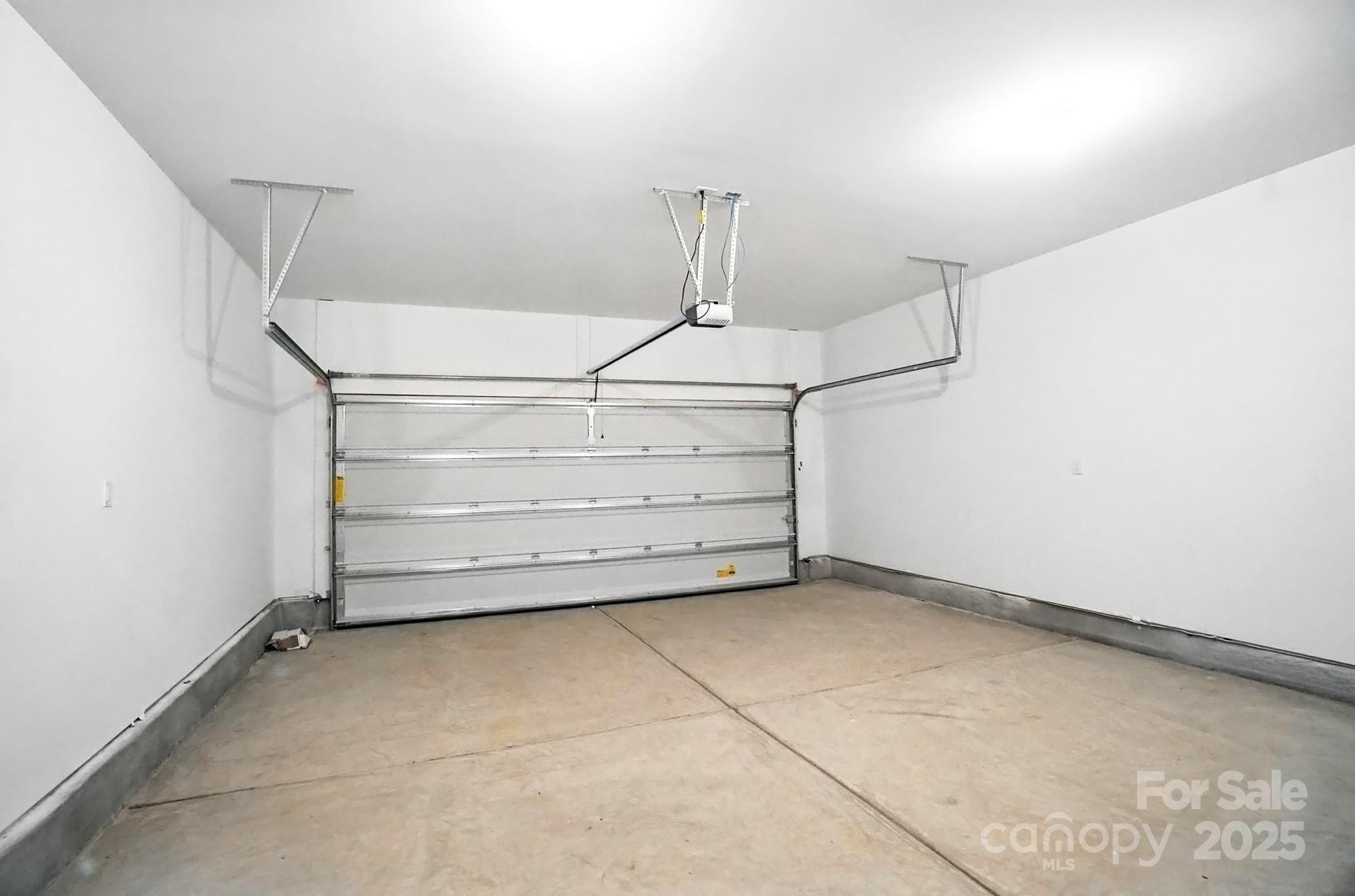 Empty garage with a concrete floor and closed overhead door.