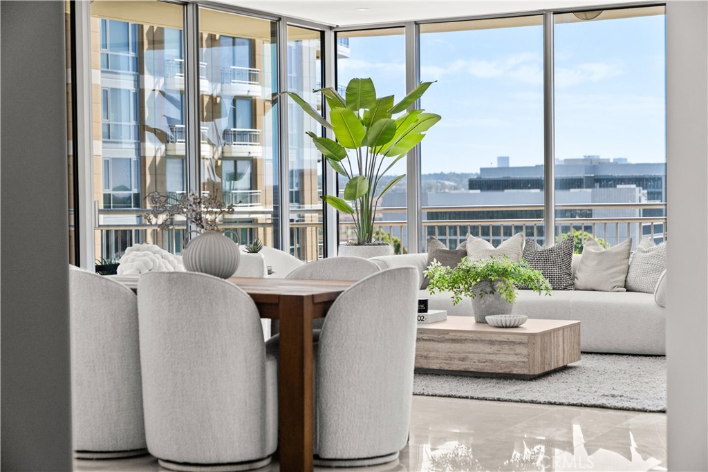 Staged condo living and dining area with a white sectional and floor-to-ceiling windows.