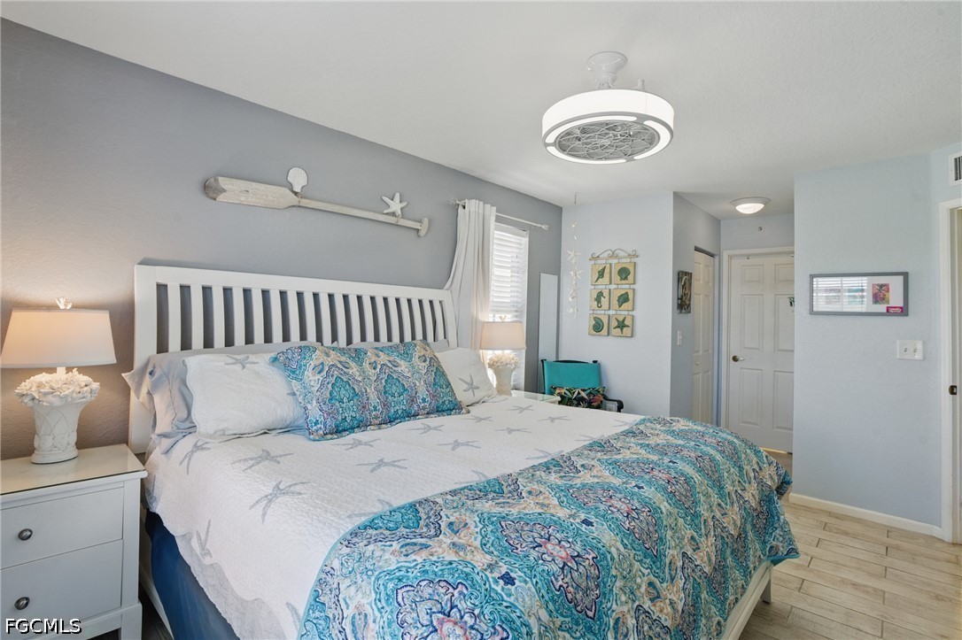 Bedroom with a large bed in blue patterned bedding and coastal decor.