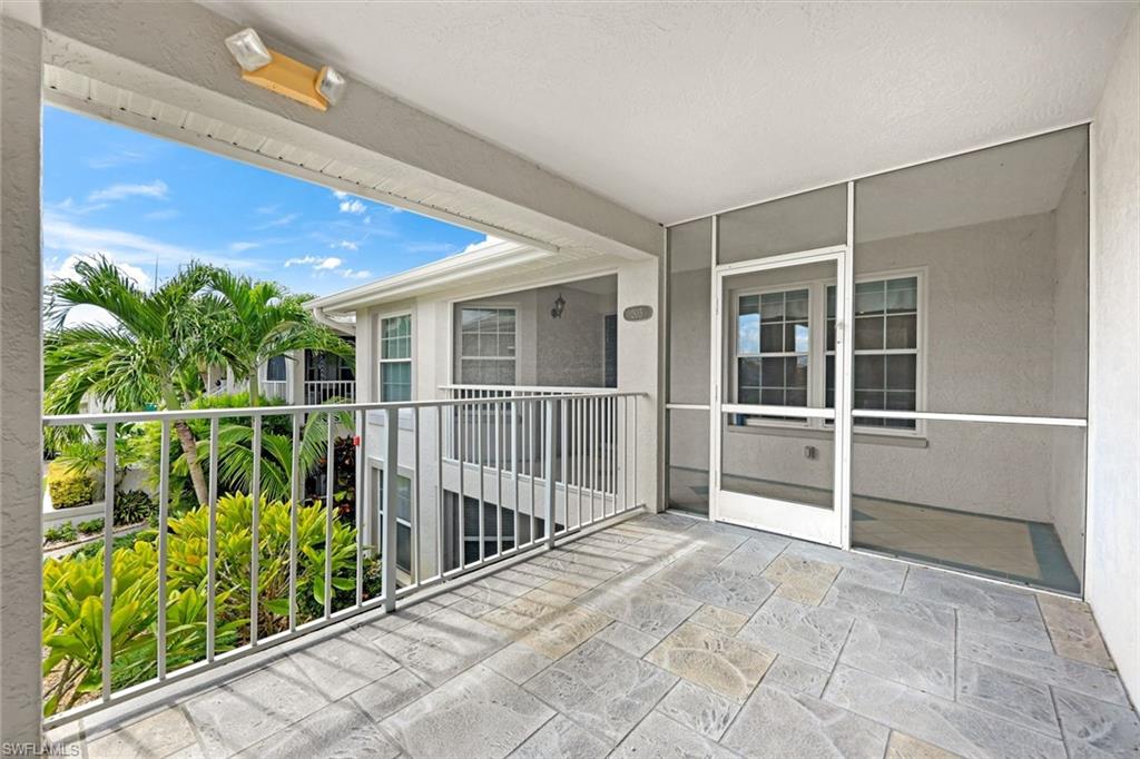 Covered tiled patio overlooking palm trees and tropical landscaping.