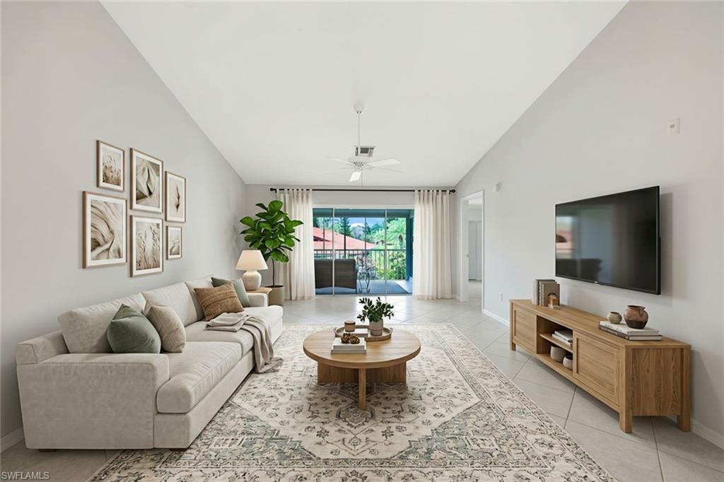Furnished living room with a high ceiling, neutral seating, and sliding doors to a lanai.