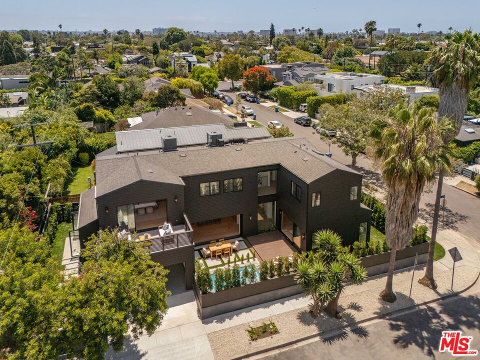 Modern two-story home with a backyard pool and wood deck, viewed from above.