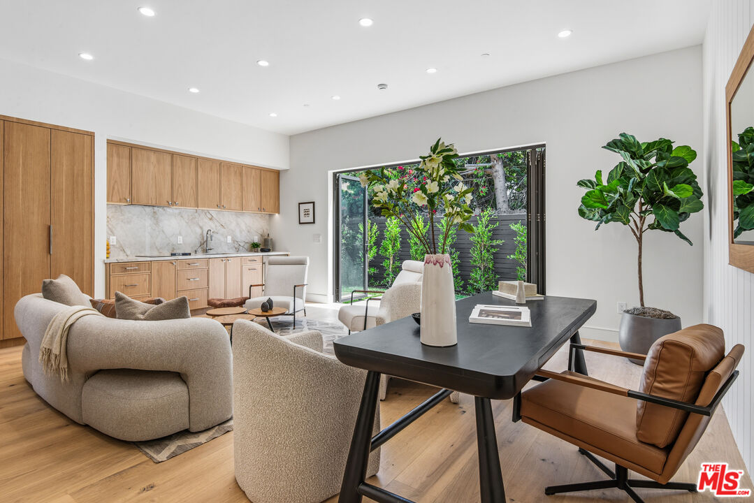 Open-plan living and dining area with a light wood kitchen and sliding doors to a garden.