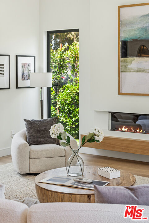 Staged living room with a round wood coffee table and linear fireplace.