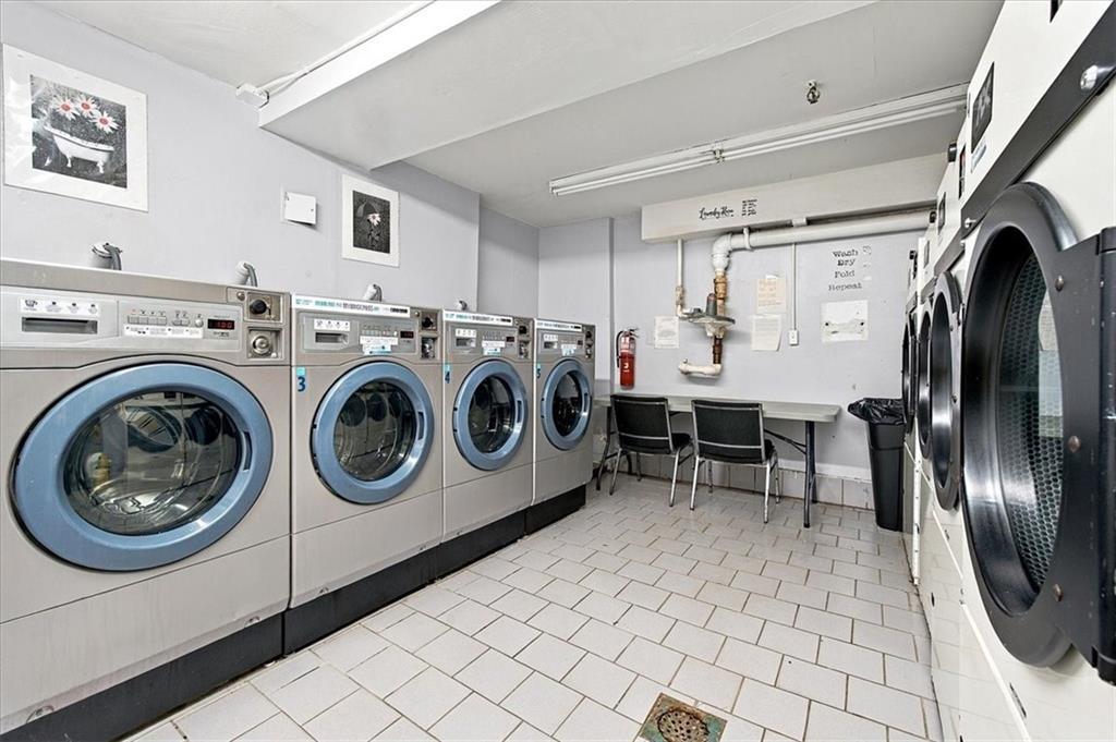 Shared laundry room with front-loading washers and dryers and a folding table.