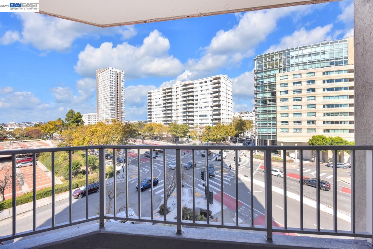 Balcony overlooking San Francisco streets, a landscaped park, and surrounding high-rise buildings.