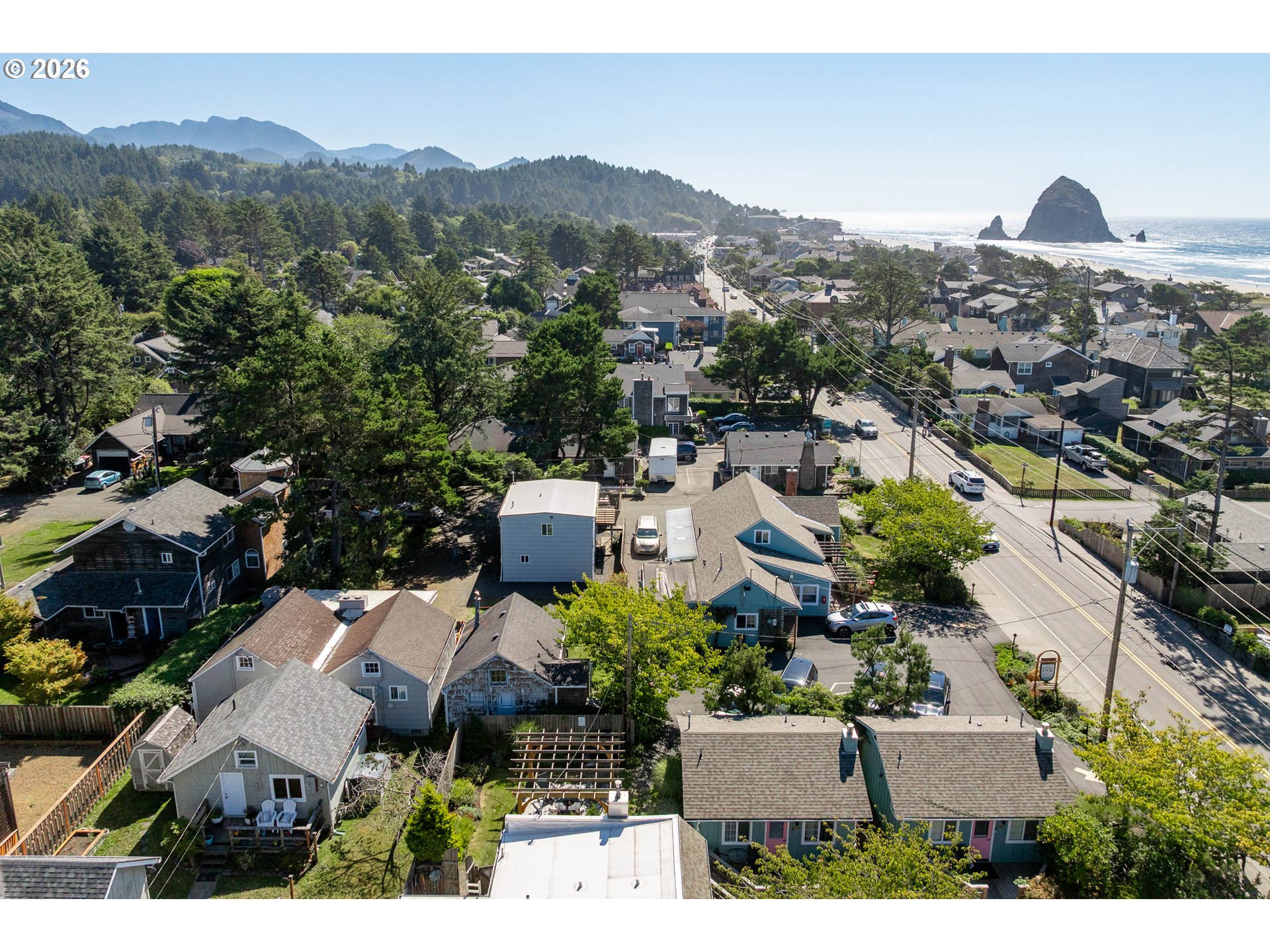 Aerial view of Cannon Beach homes, with Haystack Rock and the Pacific Ocean beyond.