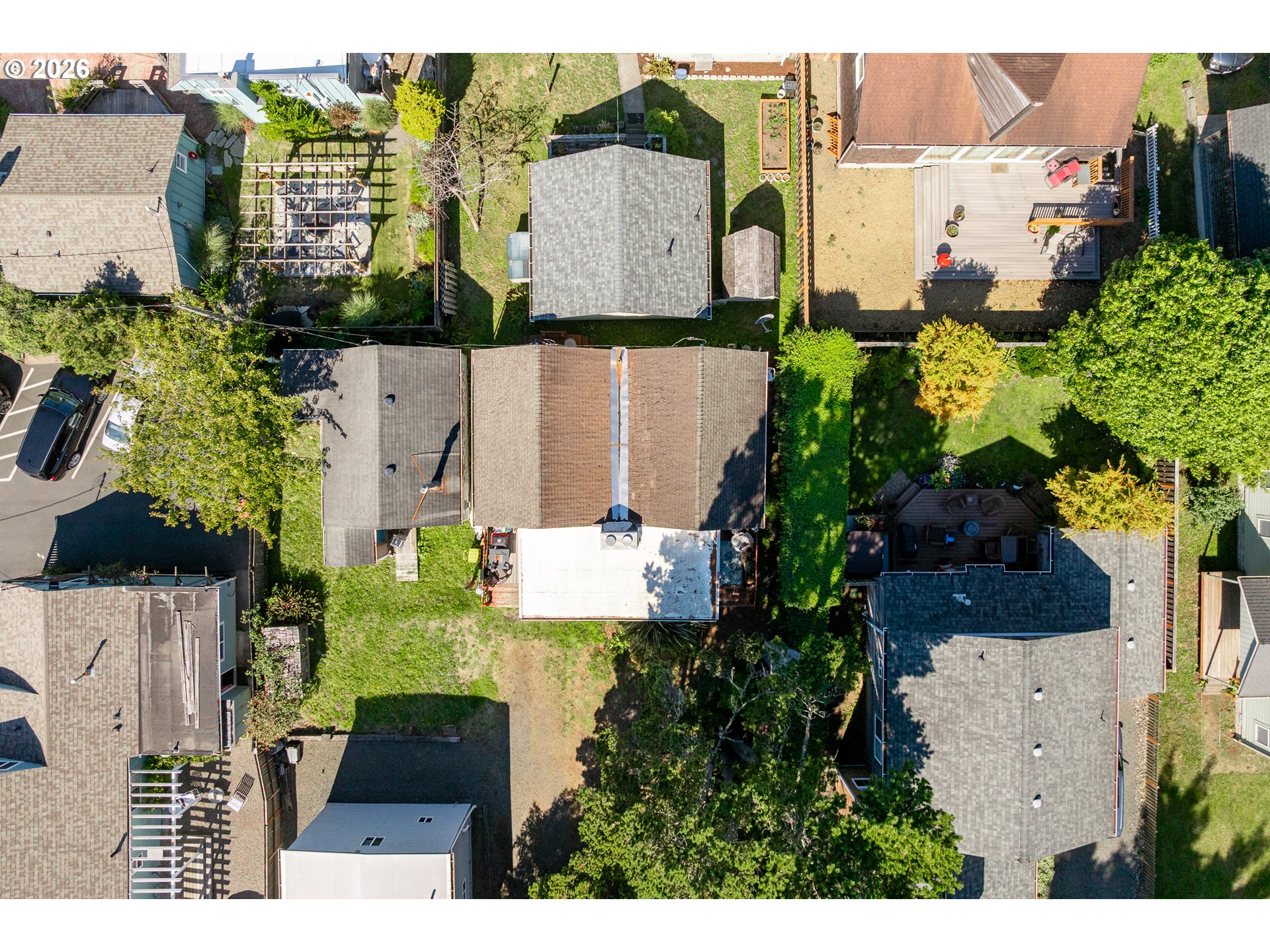 Aerial view of 138 E Jefferson, showing its brown roof, white patio, and leafy yard among neighboring homes.