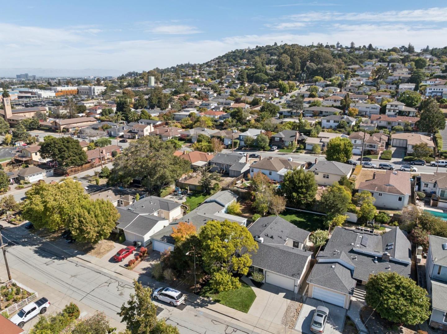 Aerial view of a residential neighborhood, with tree-lined streets and homes climbing a hillside.
