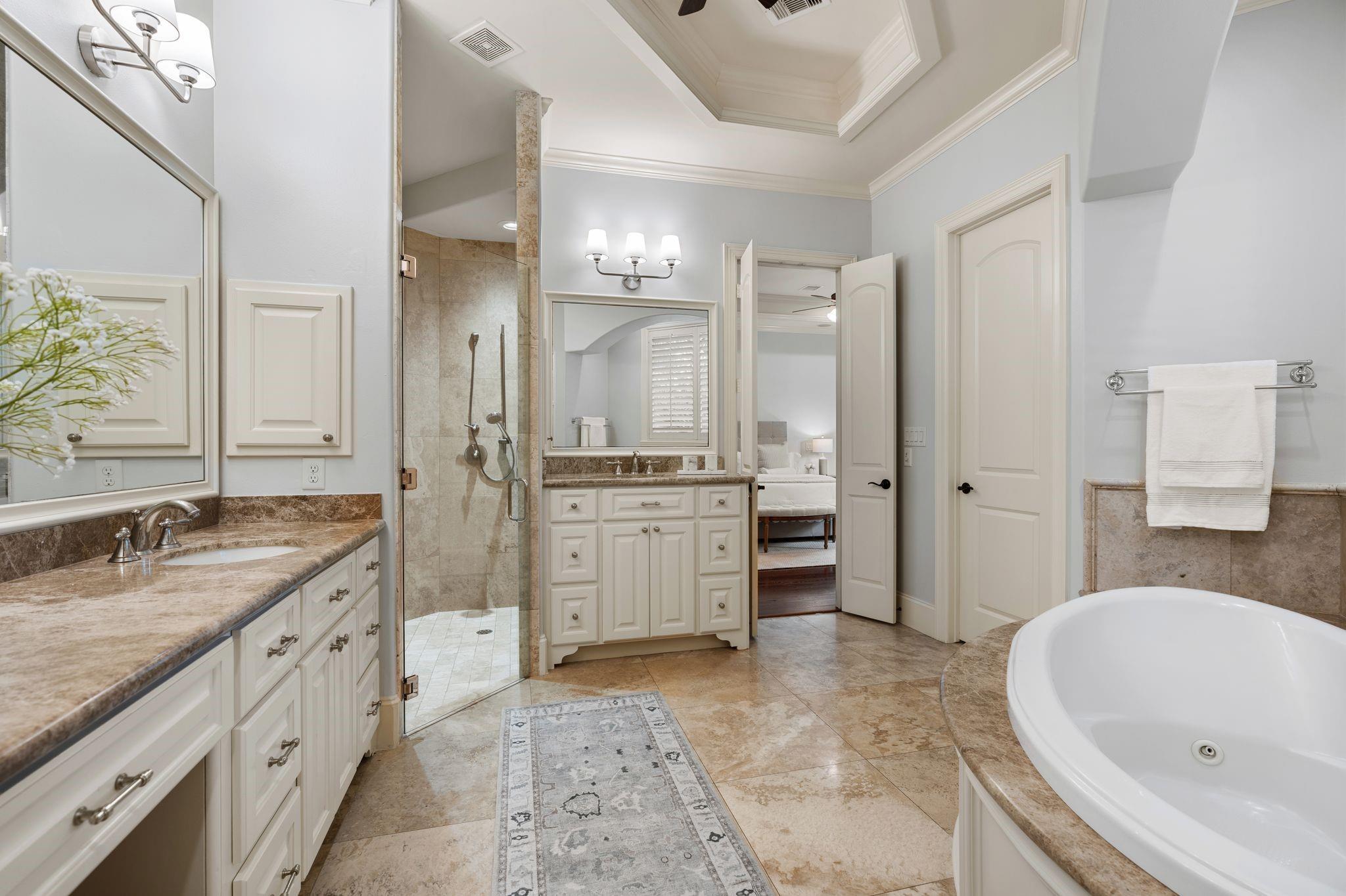 Primary bathroom with glass shower, double vanity, and soaking tub.