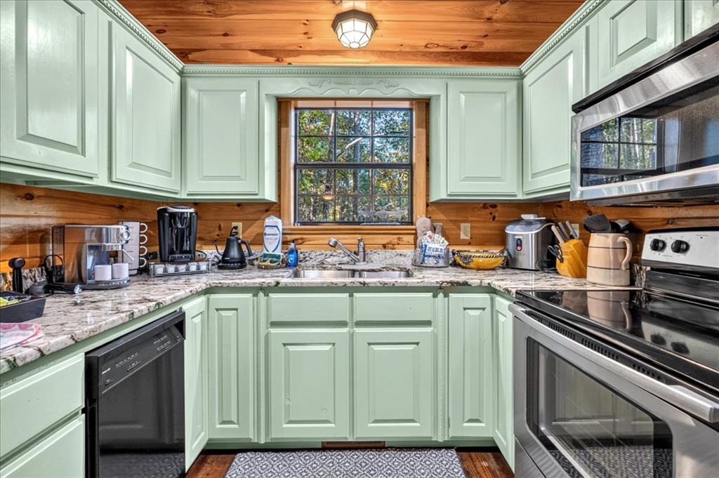Kitchen with mint-green cabinets, granite countertops, stainless-steel appliances, and a wood ceiling.