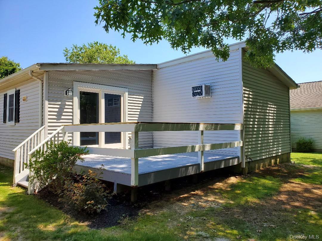Rear of a single-story home with a raised deck and white railings.