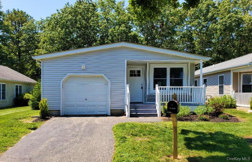 Light-blue single-story home with an attached garage and covered front porch.