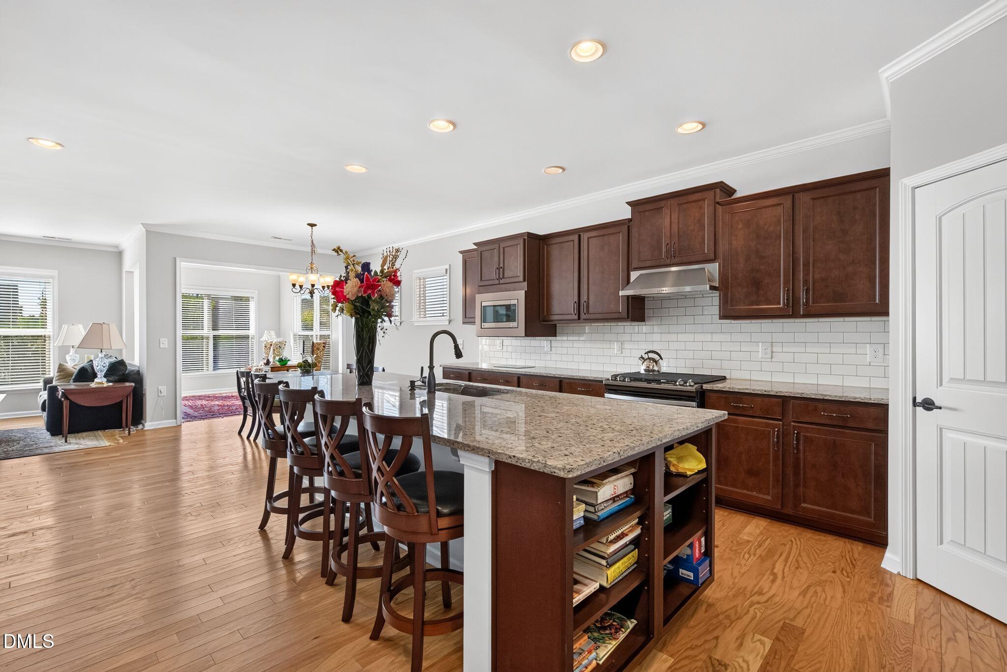 Open kitchen with a granite island, dark wood cabinets, and adjoining dining area.