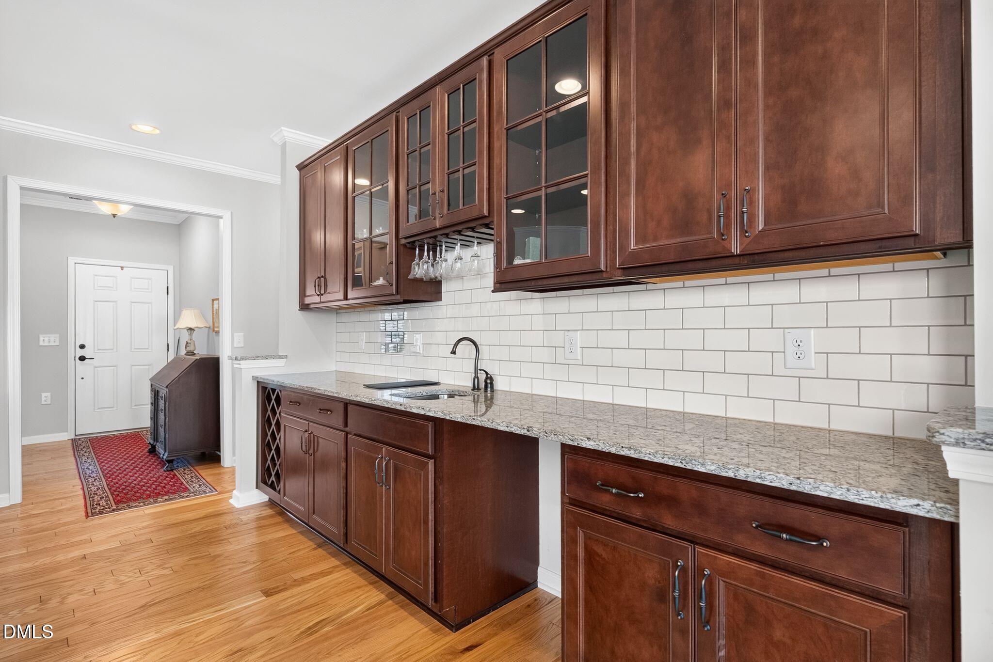 Kitchen with cherry cabinets, granite countertops, and a white subway tile backsplash.