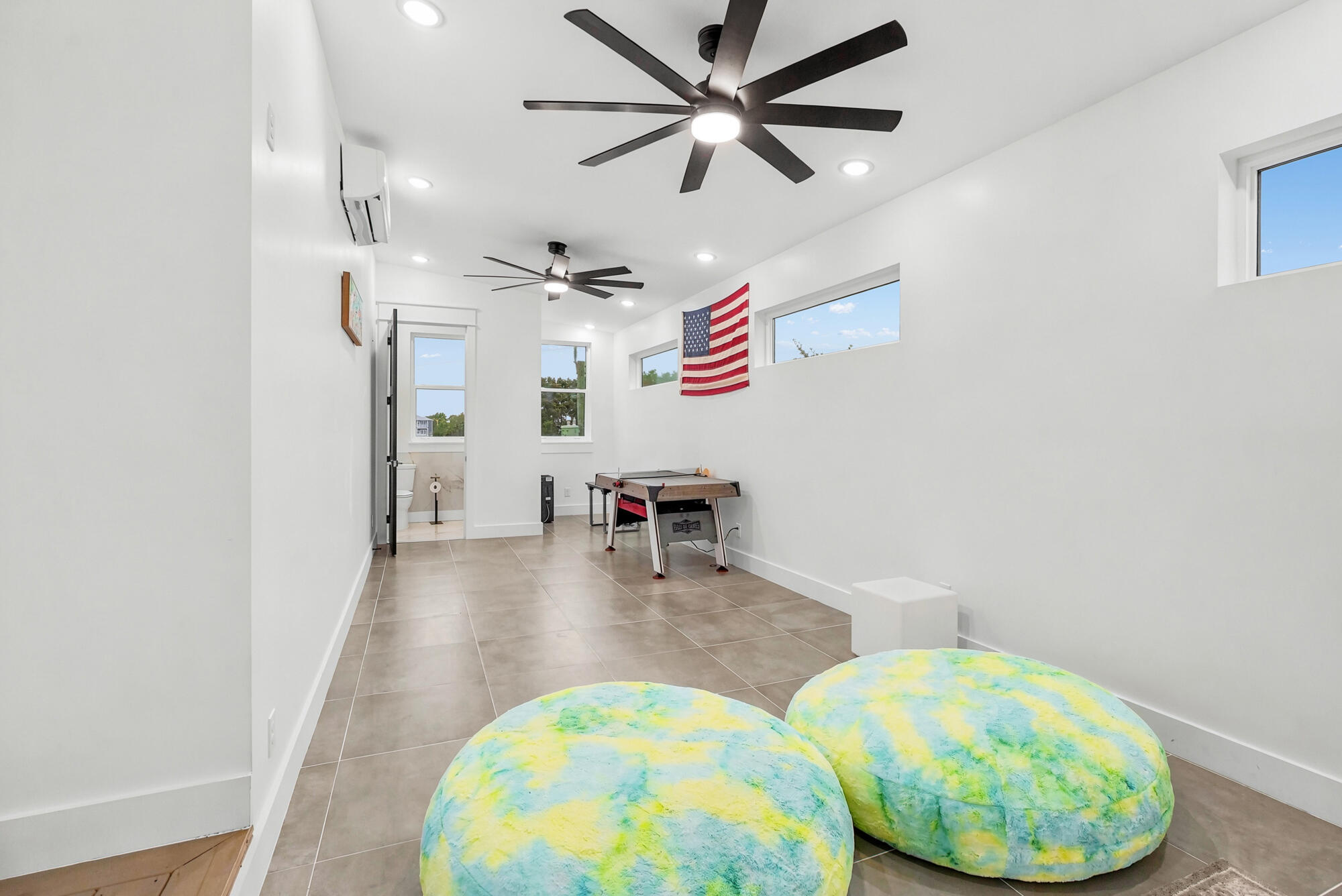 Game room with colorful beanbag chairs, a foosball table, and an American flag.