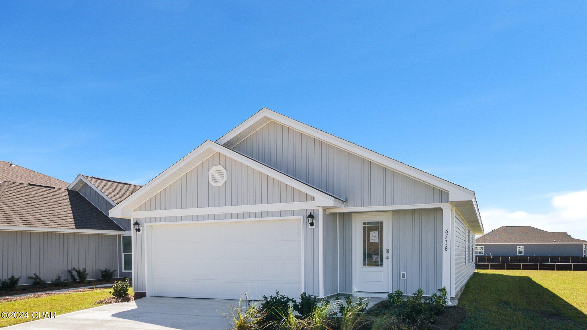 Gray single-story house with white trim, a two-car garage, and a broad gabled roof.