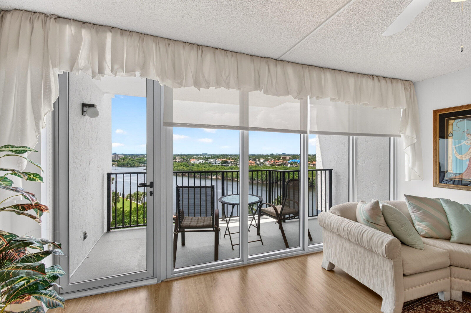 Living room with sliding glass doors opening to a balcony overlooking the water.