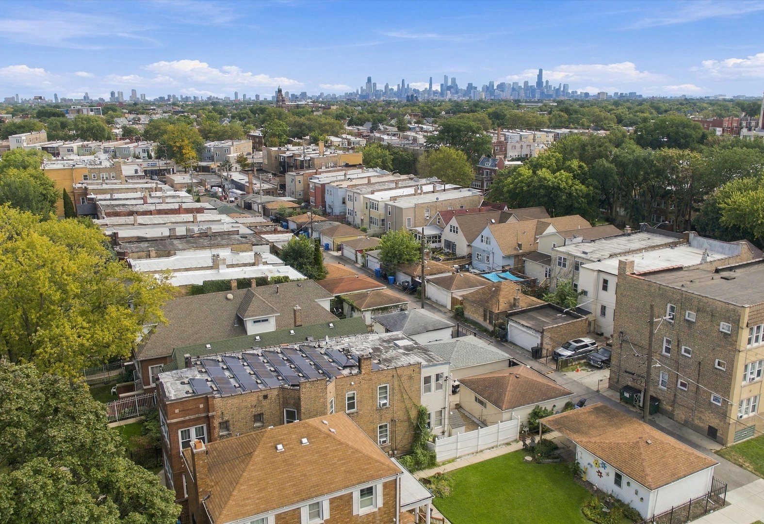 Aerial view across neighborhood rooftops toward the Chicago skyline.