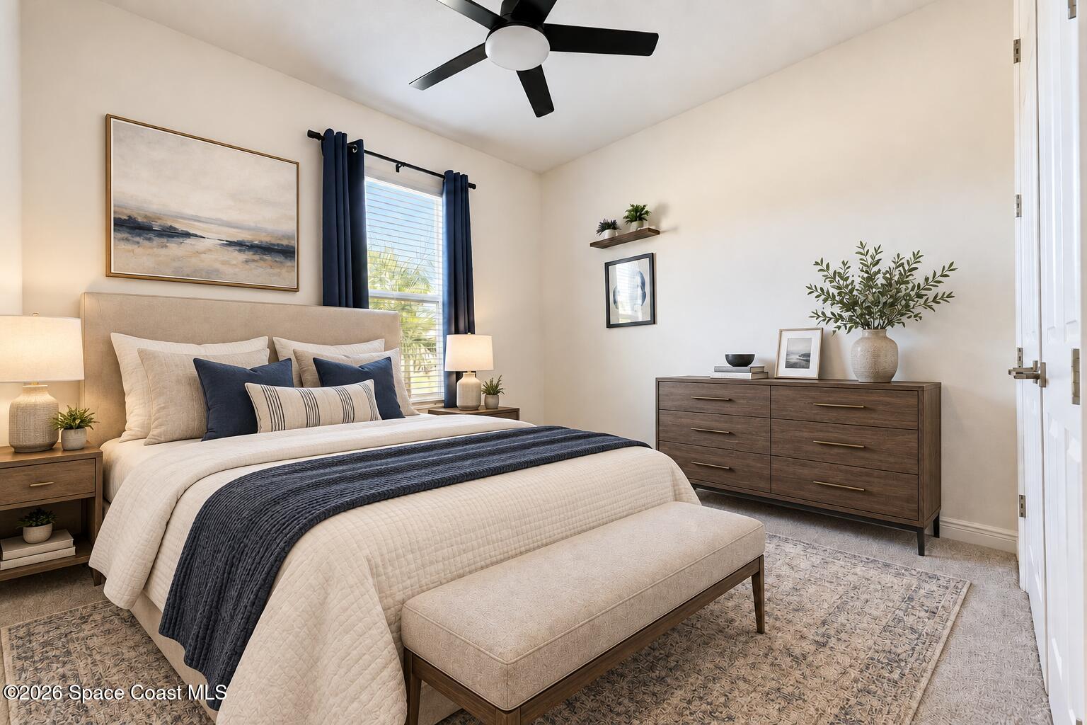 Staged bedroom with a cream bed, navy bedding accents, dark wood dresser, and window with navy curtains.