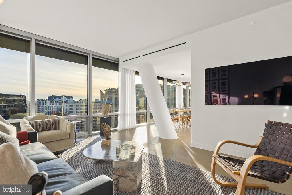 Living room with floor-to-ceiling windows, city views, contemporary furnishings, and an adjacent dining area.