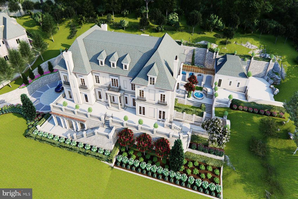 Aerial view of a large stone mansion, landscaped grounds, circular drive, and pool.
