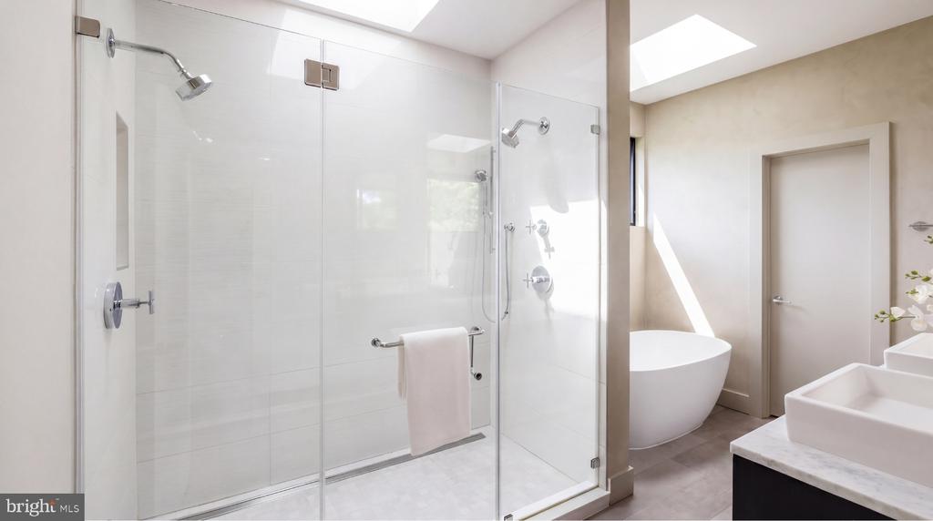 Modern bathroom with a glass walk-in shower, freestanding tub, and double vanity.