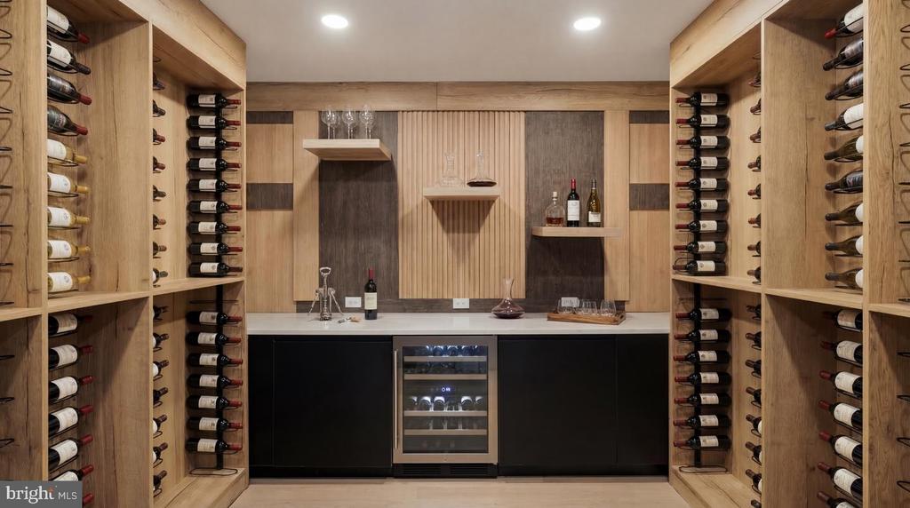 Wine cellar with full-height wood racks, a central counter, and a glass-front wine refrigerator.