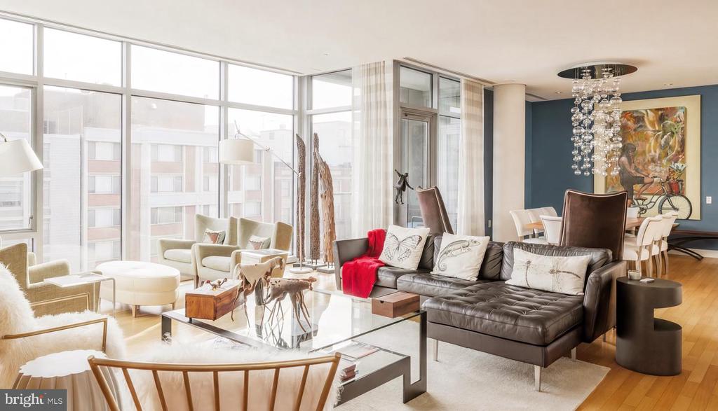 Bright condo living room with floor-to-ceiling windows, a leather sectional, and a dining area.