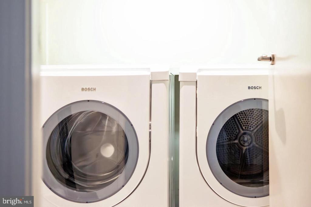 Bosch front-loading washer and dryer side by side in a laundry closet.
