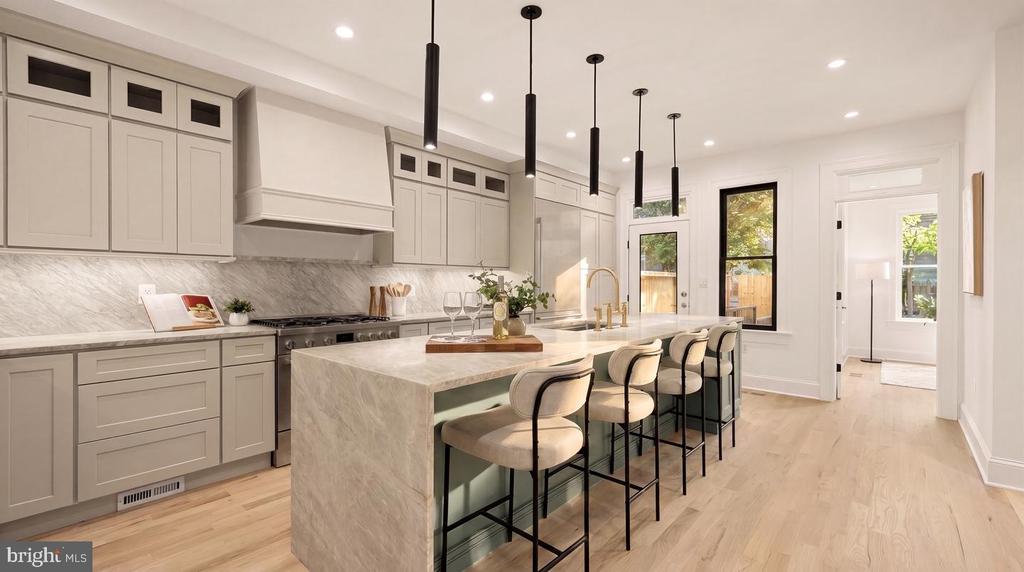 Bright white kitchen with a marble waterfall island, four bar stools, and pale wood floors.