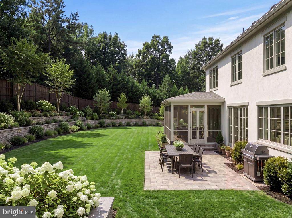 Rear of a two-story house with a screened porch, dining patio, grill, and landscaped lawn.