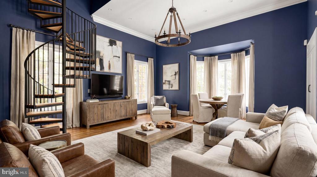 Living room with a black spiral staircase, navy walls, and a bright bay-window dining nook.