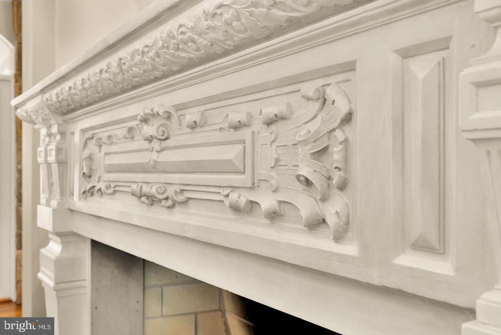 Ornately carved white fireplace mantel above a light tile surround.