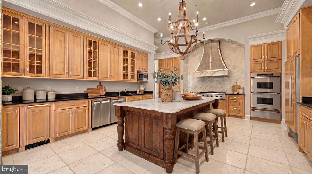 Traditional kitchen with honey-toned cabinetry, a large island, and double wall ovens.