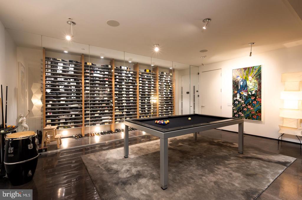 Game room with a pool table and glass-fronted wine storage spanning the back wall.