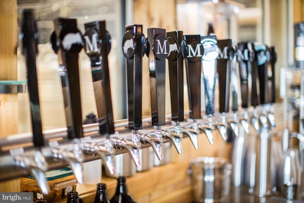 Row of beer taps with black handles and chrome spouts at a bar.