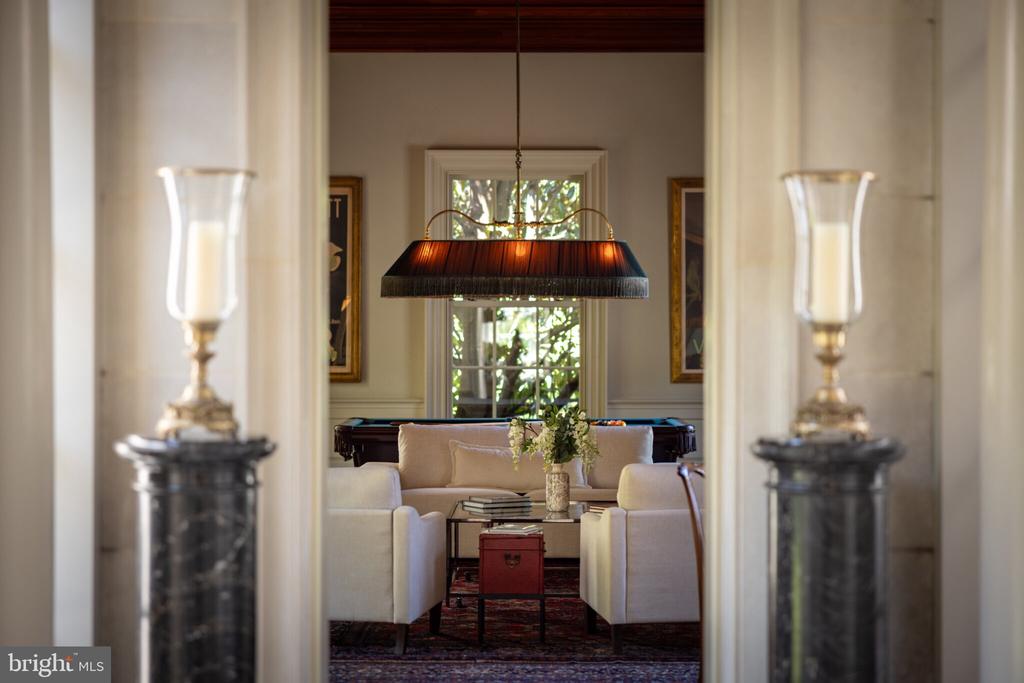 Furnished sitting room with cream sofas, a coffee table, and a pool table.