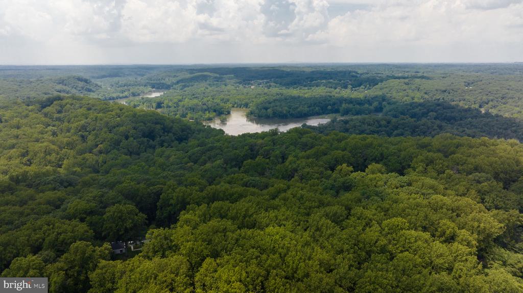 Aerial view of wooded land surrounding a broad waterway.